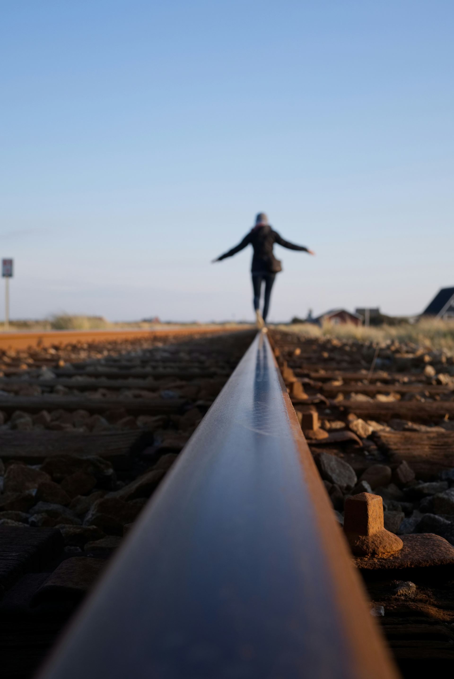 A person balances whilst walking on a silver track